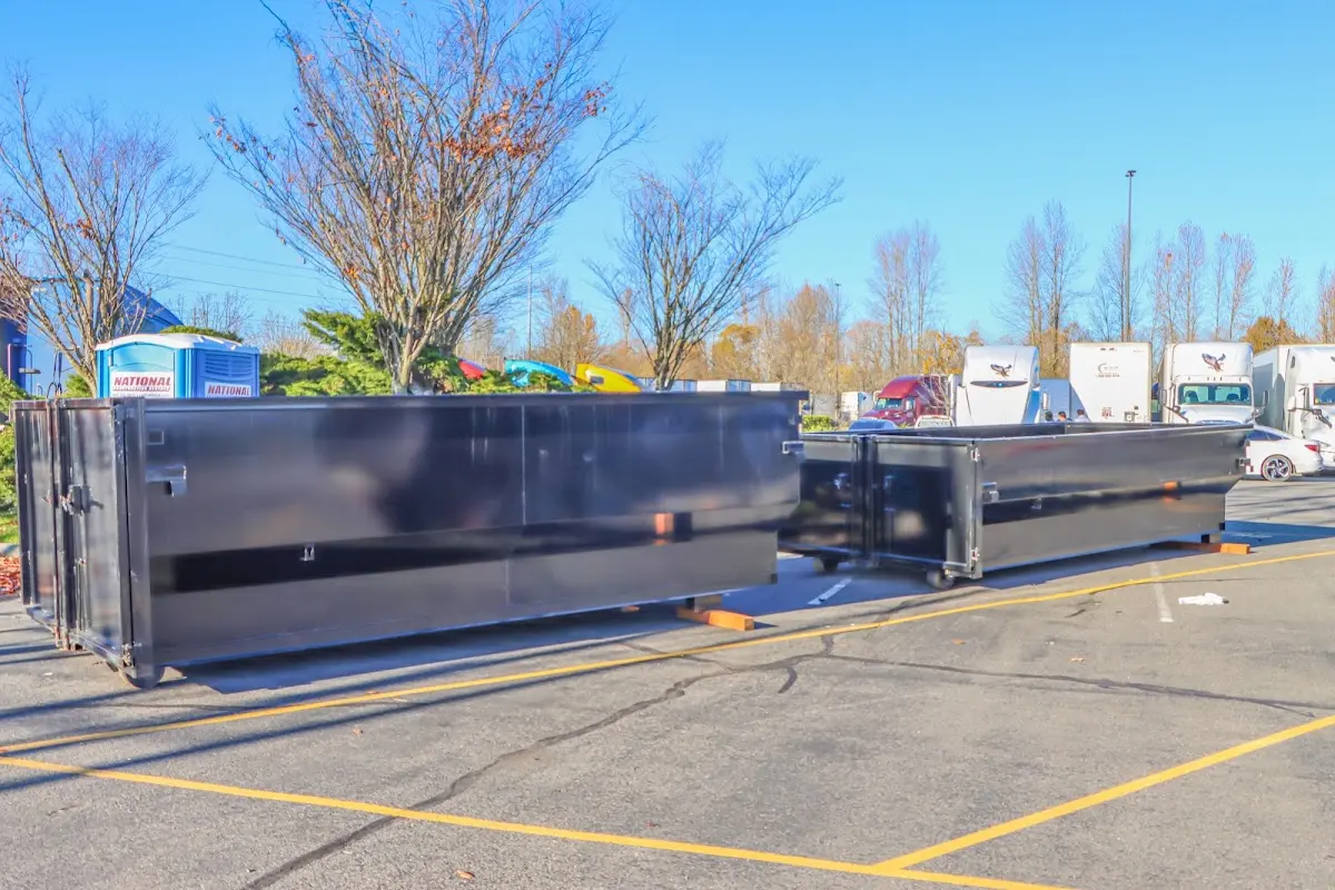 Professional dumpster rental service with roll-off container on residential driveway in Bourne